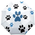 Parapluie manuel blanc avec motifs pattes noirs et bleus, idéal pour les passionnés de chiens et d'accessoires originaux.