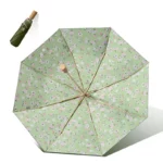 Parapluie fleur noir et beige anti-UV, design élégant et fleuri, idéal pour se protéger de la pluie et du soleil avec style.