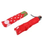 Parapluie pliable rouge motif fraises, compact et élégant, avec housse assortie, parfait pour rester stylé sous la pluie.