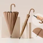 Parapluie marron uni café, un déplié et un plié, avec détails dorés et stylisés, sur fond neutre. Élégance et utilité en pluie.
