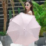 Parapluie rose pliant manuel avec dentelle froufrou, accessoire élégant, parfait pour un style chic sous le soleil.