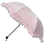 Parapluie rose pliant manuel avec bordure en dentelle, accessoire chic idéal pour mariage et occasions spéciales, design élégant rétro.
