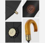 Parapluie homme pliant élégant avec poignée bois, logo cuir, verrou doré et finition noire raffinée, parfait pour toutes occasions.