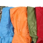 Poncho de pluie unisexe disponible en 4 couleurs vives (bleu, orange, vert, rouge) parfait pour homme et femme par temps pluvieux.