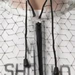 Poncho femme blanc transparent avec poche intégrée, motif hexagonal, fermeture éclair et cordons, idéal contre la pluie.