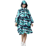 Poncho femme long avec motifs zigzag turquoise et navy, capuche et zip, élégant et pratique, protection pluie idéale.