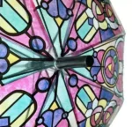 Parapluie transparent type canne, design élégants inspirés des vitraux avec nuances rose, bleu et vert, protection pluie stylée.