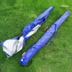 Parapluie de pêche léger bleu, doublure argentée, un ouvert et un replié, posés sur pelouse verte, idéal pour activités extérieures.