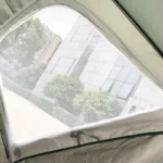 Parapluie de pêche léger, idéal pour les aventures en plein air, élégamment posé devant un paysage urbain moderne et verdoyant.