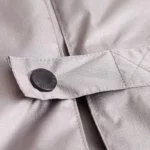 Poncho de pluie à capuche pour homme, idéal pour cyclisme et pêche, tissu gris résistant avec bouton de fermeture détaillé.