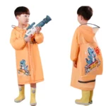 Enfant avec poncho imperméable orange motif dinosaure, bottes jaunes, ludique et coloré, parfait pour la pluie.