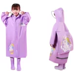 Enfant souriant avec poncho de pluie imperméable violet motif licorne, parfait pour bébé et enfant, pratique par temps humide.