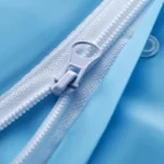 Poncho de pluie imperméable pour bébé et enfant, avec fermeture éclair blanche sur tissu bleu, idéal en cas d’intempéries.