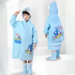 Enfant souriant portant un poncho de pluie imperméable à motifs, idéal pour jours pluvieux. Tenue pratique et joyeuse pour jeunes.