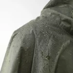 Poncho de pluie homme vert kaki imperméable, idéal pour les intempéries, avec gouttes d'eau prouvant son efficacité par temps pluvieux.