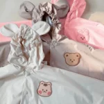 Poncho enfant imperméable avec capuchon oreilles d'ours et lapin, coloré et ludique, idéal pour les jours de pluie.