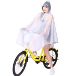 Femme en poncho transparent imperméable avec capuche, assise sur vélo jaune, idéale pour cyclistes et scooters sous la pluie.