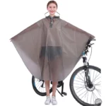 Femme souriante avec poncho pluie transparent, protection idéale pour vélo et scooter, combinaison mode et fonctionnalité.