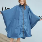 Poncho de pluie bleu pour femme taille L, manches larges, pratique avec fermeture éclair, parfait pour rester au sec élégamment.