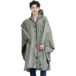Femme portant un poncho de pluie vert taille L, imperméable et élégant, idéal pour protection sous la pluie. Collection moderne.