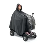 Poncho de pluie noir sur scooter électrique, protection imperméable intégrale pour conducteur et véhicule par temps pluvieux.