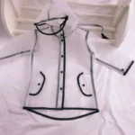 Poncho enfant transparent imperméable avec capuche, bordures noires et poches, parfait pour rester au sec les jours de pluie.