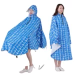 Poncho vélo femme bleu à motifs géométriques, avec capuche et visière amovible. Élégant et pratique pour les jours de pluie.