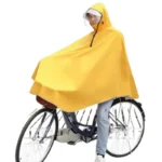Poncho vélo femme jaune avec visière amovible, design ample et élégant, idéal pour se protéger de la pluie en roulant à vélo.