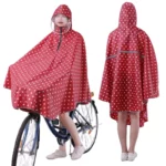 Poncho vélo femme avec visière amovible, design rouge à pois, protection pluie pratique et élégante pour cyclistes.