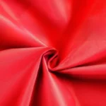 Poncho vélo femme classique rouge en tissu imperméable, élégant et pratique pour une protection optimale contre la pluie.