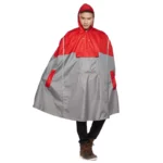 Homme souriant portant un poncho vélo gris bicolore à visière, parfait pour se protéger de la pluie avec style et praticité.