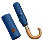 Parapluie homme pliant bleu, élégant avec manche en bois et étui assorti, pratique et chic pour se protéger de la pluie.