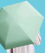 Parapluie compact vert menthe élégant, ouvert sur fond bleu, idéal pour protection contre la pluie et facile à transporter.