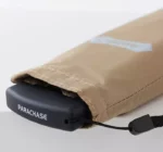Parapluie beige plié avec housse, bouton noir PARACHASE, élégant et compact, idéal pour un style chic et pratique.