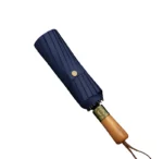 Parapluie homme chic pliable bleu marine avec poignée en bois, accessoire élégant de la collection pour protection contre la pluie.