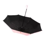 Joli parapluie rose manuel avec motif doube-coeur, à l'envers, ony vois le dessous.