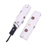 Beau parapluie blanc automatique avec un motif sur sa toile de tête d'ourson.