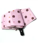 Beau parapluie rose automatique avec un beau motif de tête d'ourson.