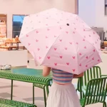 Magnifique parapluie manuel rose avec des cœurs sur le dessus, pour femme.