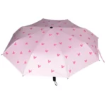 Parapluie manuel pour femme de couleur rose avec des cœurs sur le dessus.
