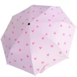 Parapluie femme manuel rose avec des cœurs sur le dessus.