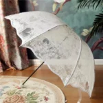 Parapluie cloche blanc à motif dentelle sympa pour un mariage, forme de coeur sur sa toile.