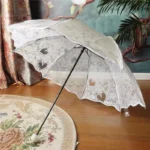 Parapluie cloche blanc à motif dentelle de qualité, forme de coeur sur sa toile, poignée blanche.