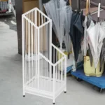 J'aime ce porte-parapluie blanc en métal à barreaux verticaux pour le hall d'entrée de mon hôtel !