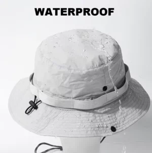 Chapeau de pluie gris clair waterproof avec cordon ajustable. Résiste à la pluie fine et aux averses, idéal pour les sorties en plein air.