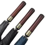 Trois parapluies assortis bleu, noir et gris, manches bois dorés, collection élégante pour un style distingué.