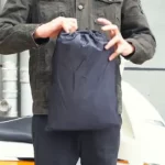 Sac de rangement compact pour tablier scooter. Léger, imperméable et pratique pour transporter votre protection contre la pluie.