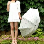 Joli parapluie blanc orné de fleurs. Design raffiné, idéal pour les journées pluvieuses. Solide, élégant et intemporel.