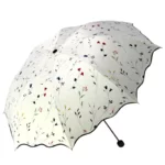 Parapluie blanc à ouverture manuelle. Motifs floraux fins, protection élégante contre la pluie et le vent. Léger et féminin.