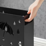 Poignée latérale découpée pour un transport facile. Structure en métal noir robuste de ce porte parapluie en métal noir, bords sécurisés, idéal pour déplacer le porte-parapluie 41×28×12 cm sans effort.
